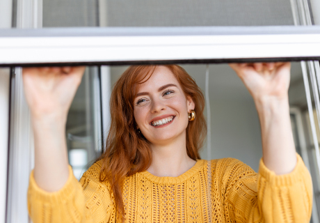 Frau macht glücklich ihr Fenster zu | mmobiliengutachter Bad Kissingen