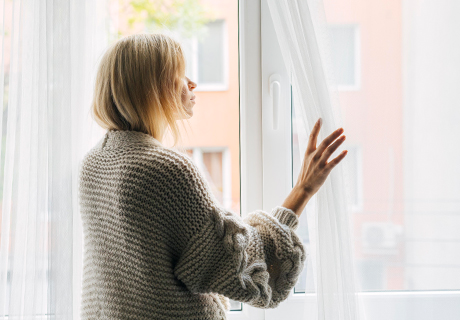 Frau schaut aus Fenster | Immobilien Bad Kissingen